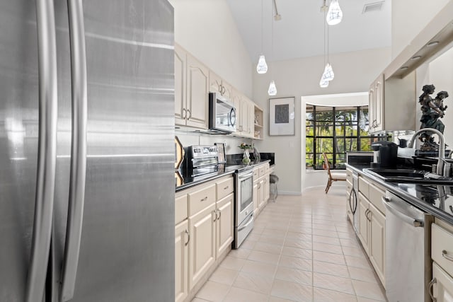 kitchen with hanging light fixtures, high vaulted ceiling, light tile patterned floors, stainless steel appliances, and sink