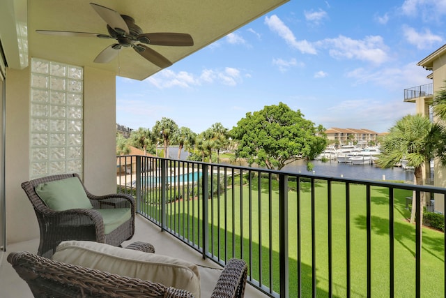 balcony with a water view and ceiling fan