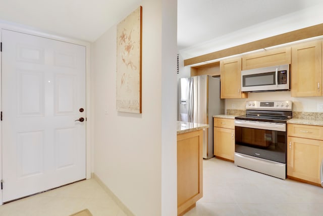 kitchen featuring light brown cabinetry, appliances with stainless steel finishes, and light stone countertops