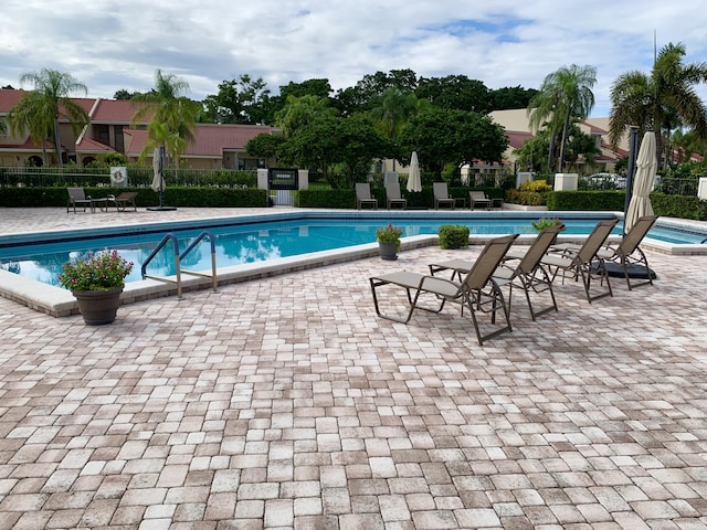 pool featuring a patio area and fence