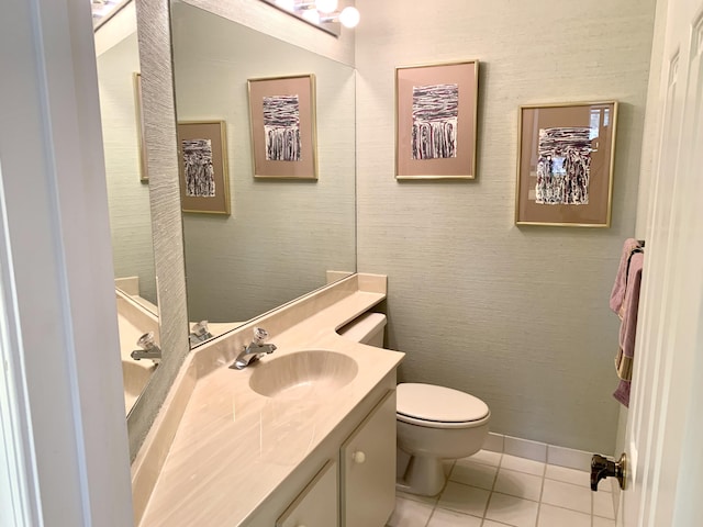 bathroom with toilet, tile patterned flooring, baseboards, and vanity