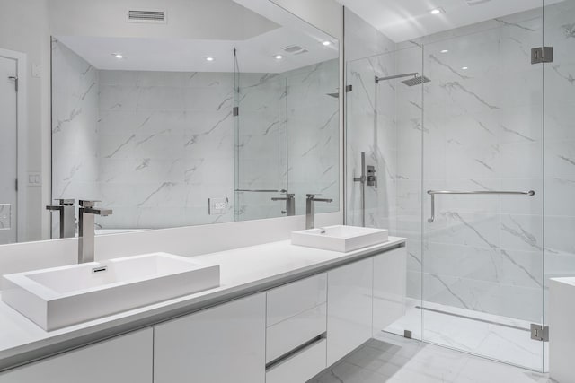 bathroom featuring a shower with door and vanity