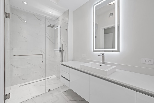 bathroom with vanity and a shower with door