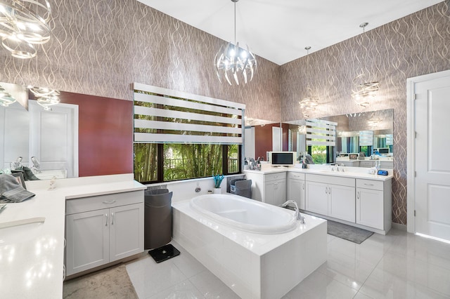 bathroom featuring vanity, tile patterned flooring, and tiled bath