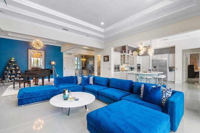 tiled living room with sink, a chandelier, a tray ceiling, and ornamental molding