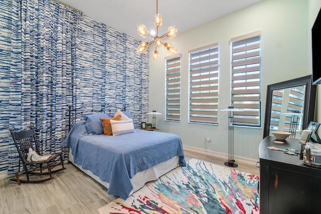 bedroom featuring an inviting chandelier and wood-type flooring