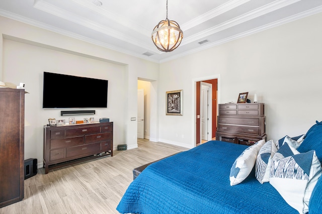 bedroom with a raised ceiling, a chandelier, ornamental molding, and light hardwood / wood-style floors