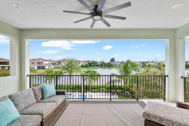 balcony with ceiling fan and a water view