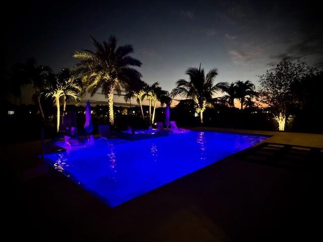 view of pool at twilight