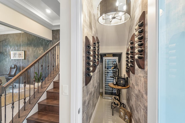 wine room featuring beverage cooler, an inviting chandelier, and crown molding