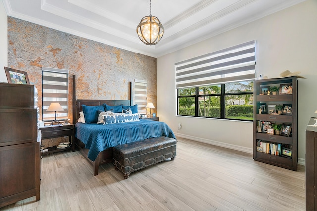 bedroom featuring an inviting chandelier, light hardwood / wood-style floors, and crown molding