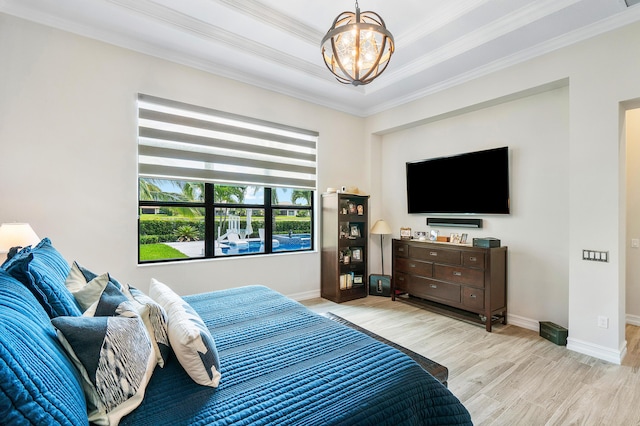 bedroom featuring a notable chandelier, light hardwood / wood-style flooring, and ornamental molding