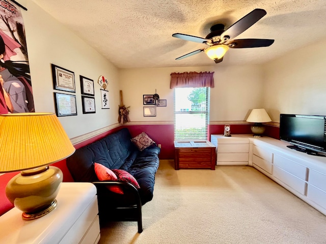 living room with ceiling fan, light carpet, and a textured ceiling