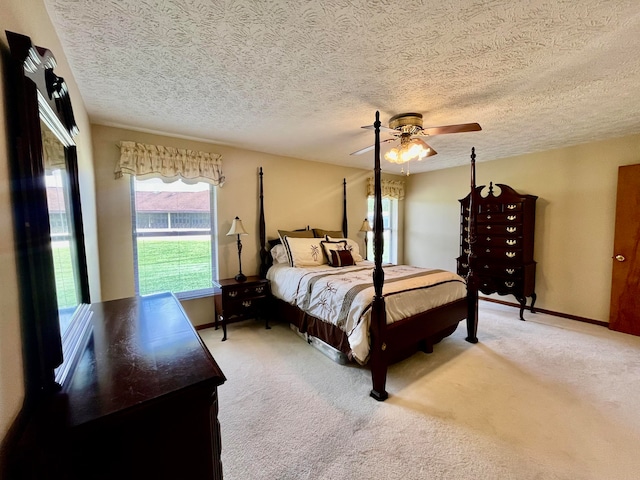 carpeted bedroom featuring a textured ceiling and ceiling fan