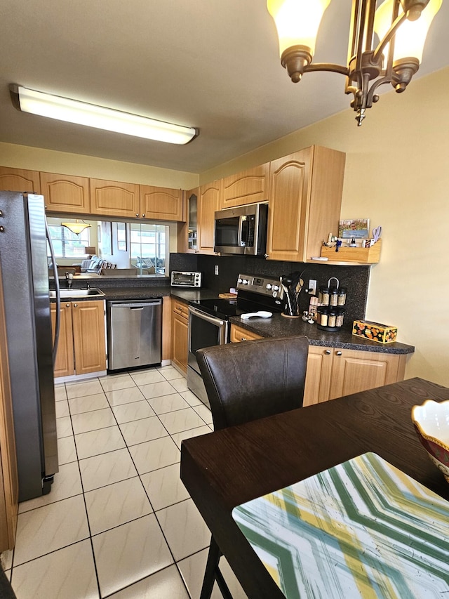 kitchen with light tile patterned floors, stainless steel appliances, a chandelier, sink, and decorative backsplash