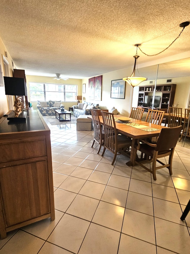 dining area featuring a textured ceiling, ceiling fan, and light tile patterned floors