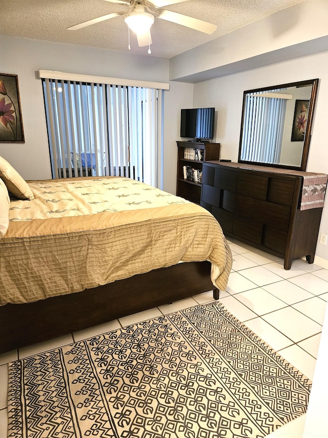 tiled bedroom with a textured ceiling and ceiling fan