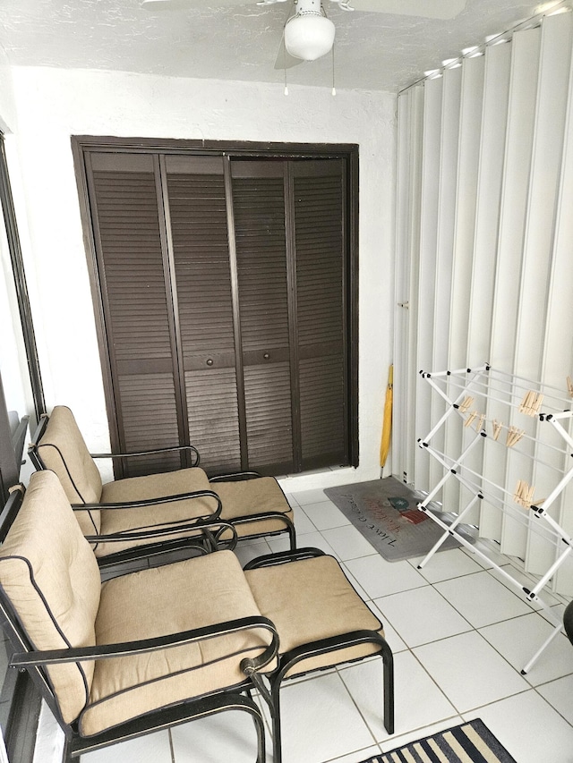 bedroom featuring a textured ceiling, ceiling fan, light tile patterned flooring, and a closet