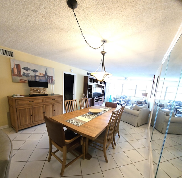 tiled dining space with a textured ceiling