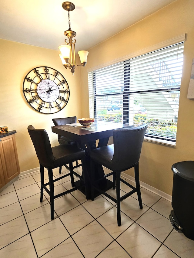 tiled dining space with a chandelier