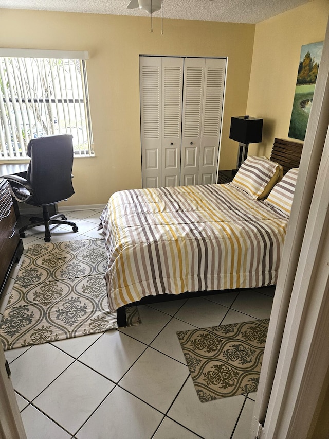 bedroom with a closet, a textured ceiling, and tile patterned floors