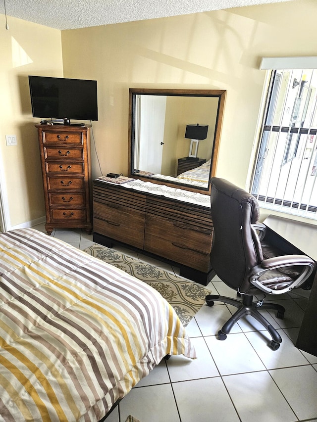 bedroom with a textured ceiling and light tile patterned floors