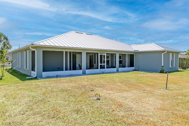 back of house with a lawn and a sunroom