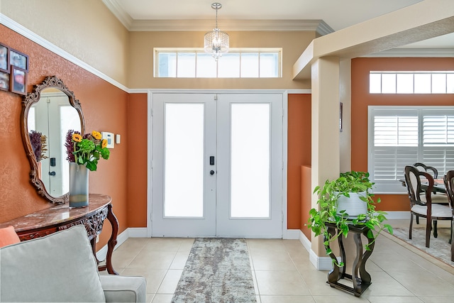 tiled foyer entrance featuring a healthy amount of sunlight, crown molding, and french doors