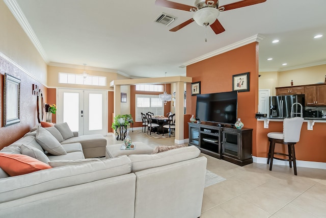 living room with crown molding, light tile patterned flooring, ceiling fan, and french doors