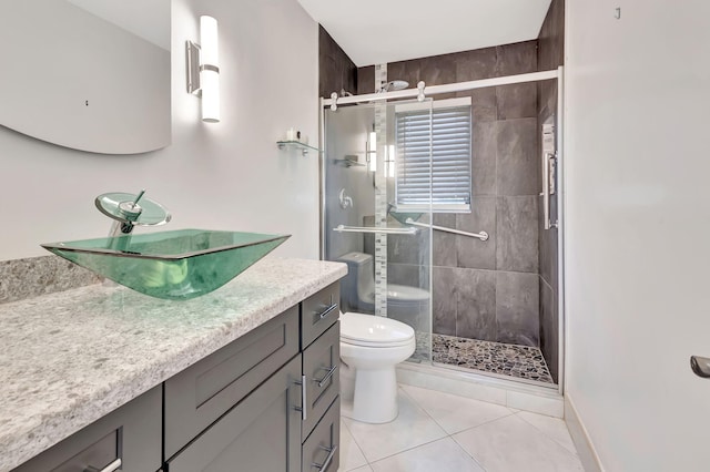 bathroom with tile patterned floors, toilet, a shower with door, and vanity