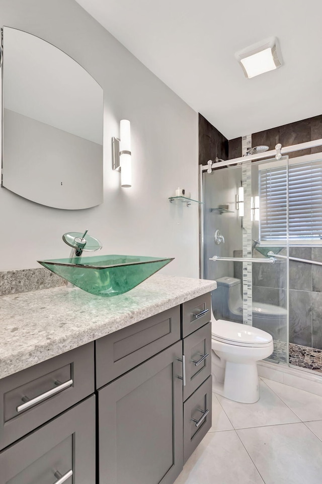 bathroom featuring an enclosed shower, tile patterned flooring, toilet, and vanity