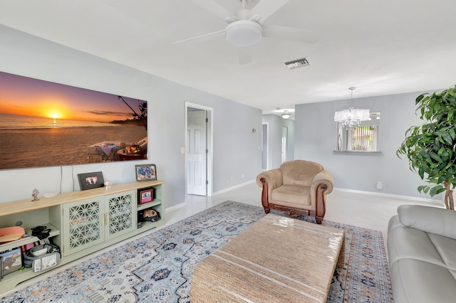 carpeted living room with ceiling fan with notable chandelier