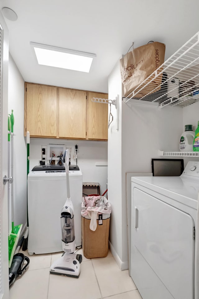 washroom with cabinets, separate washer and dryer, and light tile patterned floors