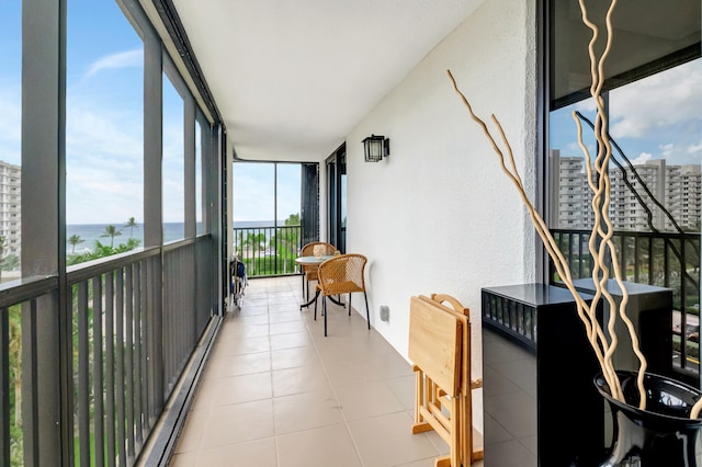 sunroom featuring a water view