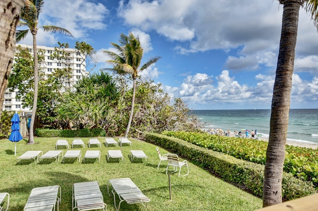 surrounding community with a view of the beach, a water view, and a yard