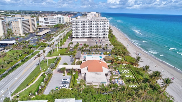 birds eye view of property with a water view and a beach view