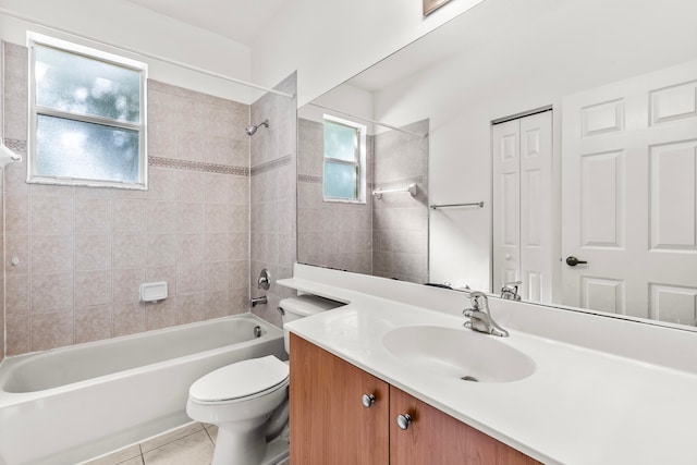 full bathroom featuring tile patterned flooring, toilet, tiled shower / bath, and vanity