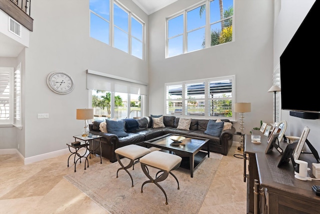 living area featuring visible vents, baseboards, and crown molding