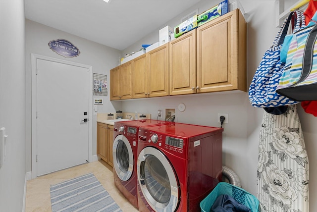 clothes washing area featuring cabinet space, independent washer and dryer, and a sink