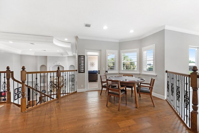 dining room featuring a wealth of natural light, visible vents, baseboards, and wood finished floors