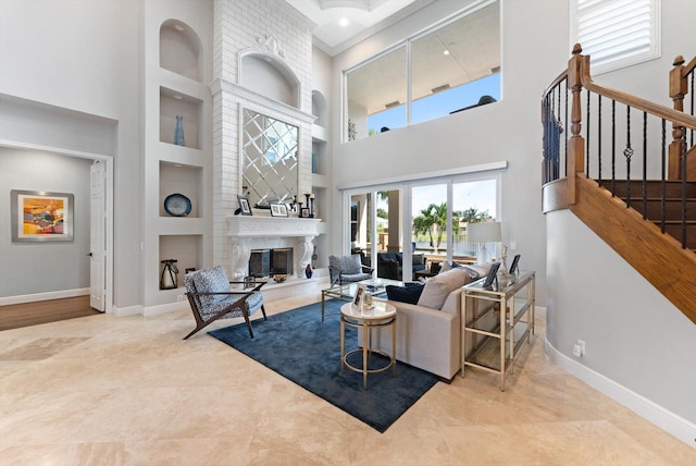 living room featuring stairway, built in features, baseboards, and a high end fireplace