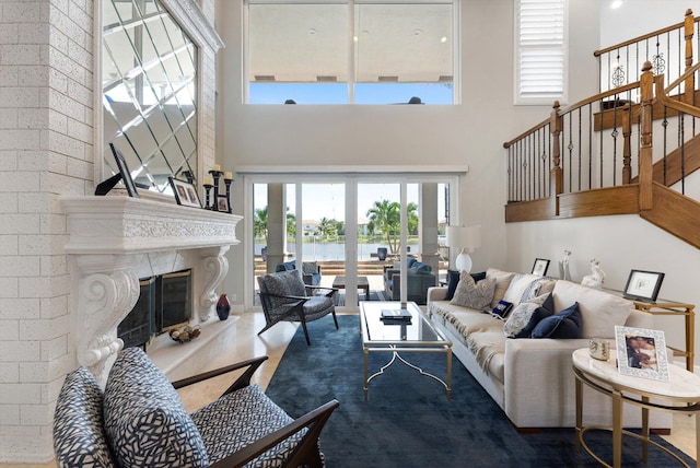 living room with a premium fireplace, a high ceiling, and stairway