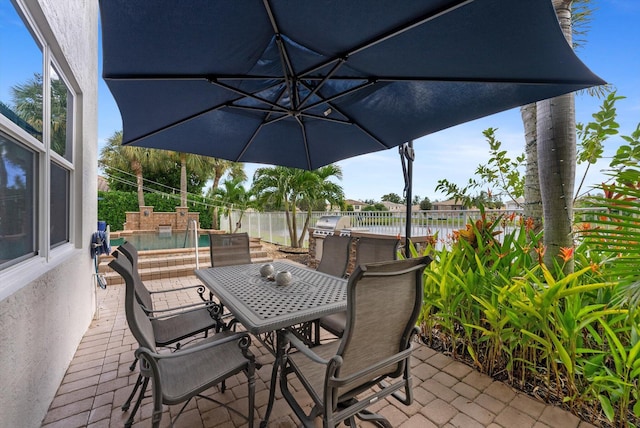 view of patio featuring outdoor dining area, a fenced backyard, and a fenced in pool