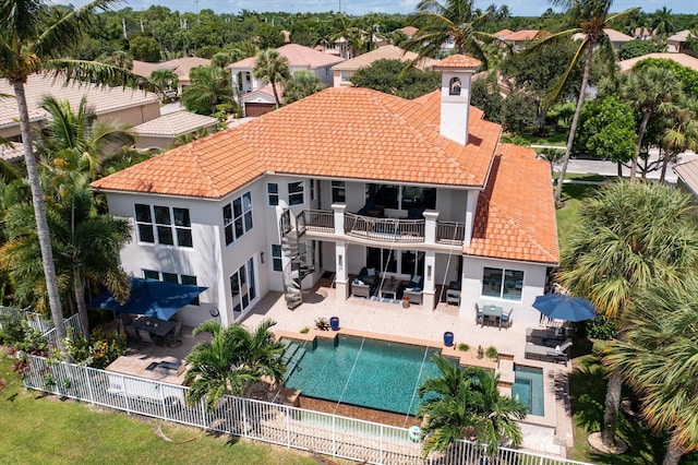 back of property with a balcony, outdoor dining area, a fenced backyard, stucco siding, and an outdoor hangout area