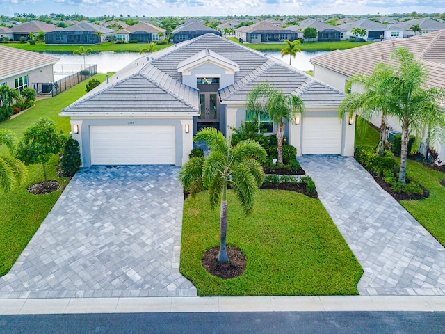 view of front of home featuring a front yard, a garage, and a water view