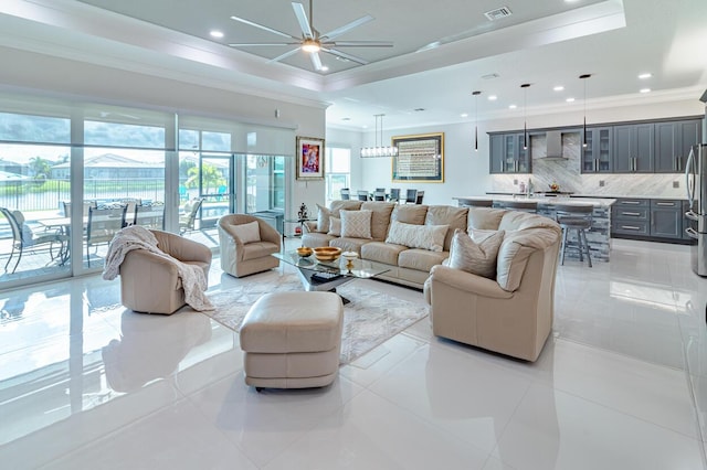 living area featuring visible vents, a ceiling fan, a tray ceiling, recessed lighting, and crown molding