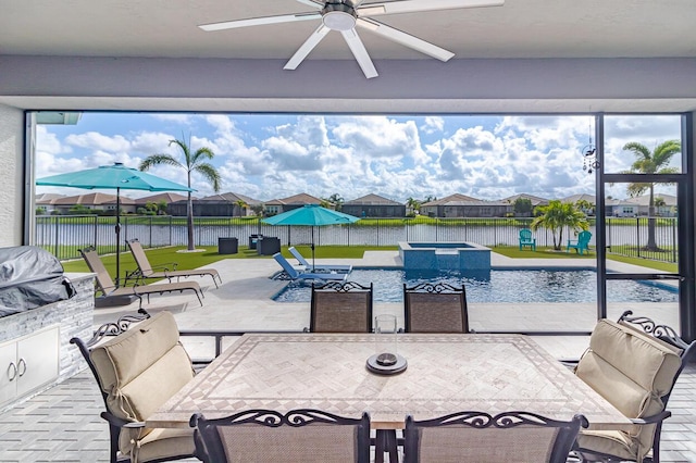 view of patio / terrace with a water view, outdoor dining space, a ceiling fan, a pool with connected hot tub, and fence