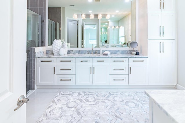 bathroom with visible vents, a stall shower, and vanity