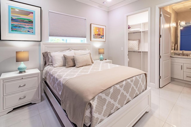 bedroom featuring ornamental molding, ensuite bath, a closet, light tile patterned floors, and a spacious closet