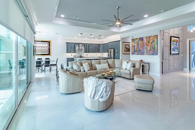 living room featuring recessed lighting, a raised ceiling, baseboards, and ornamental molding